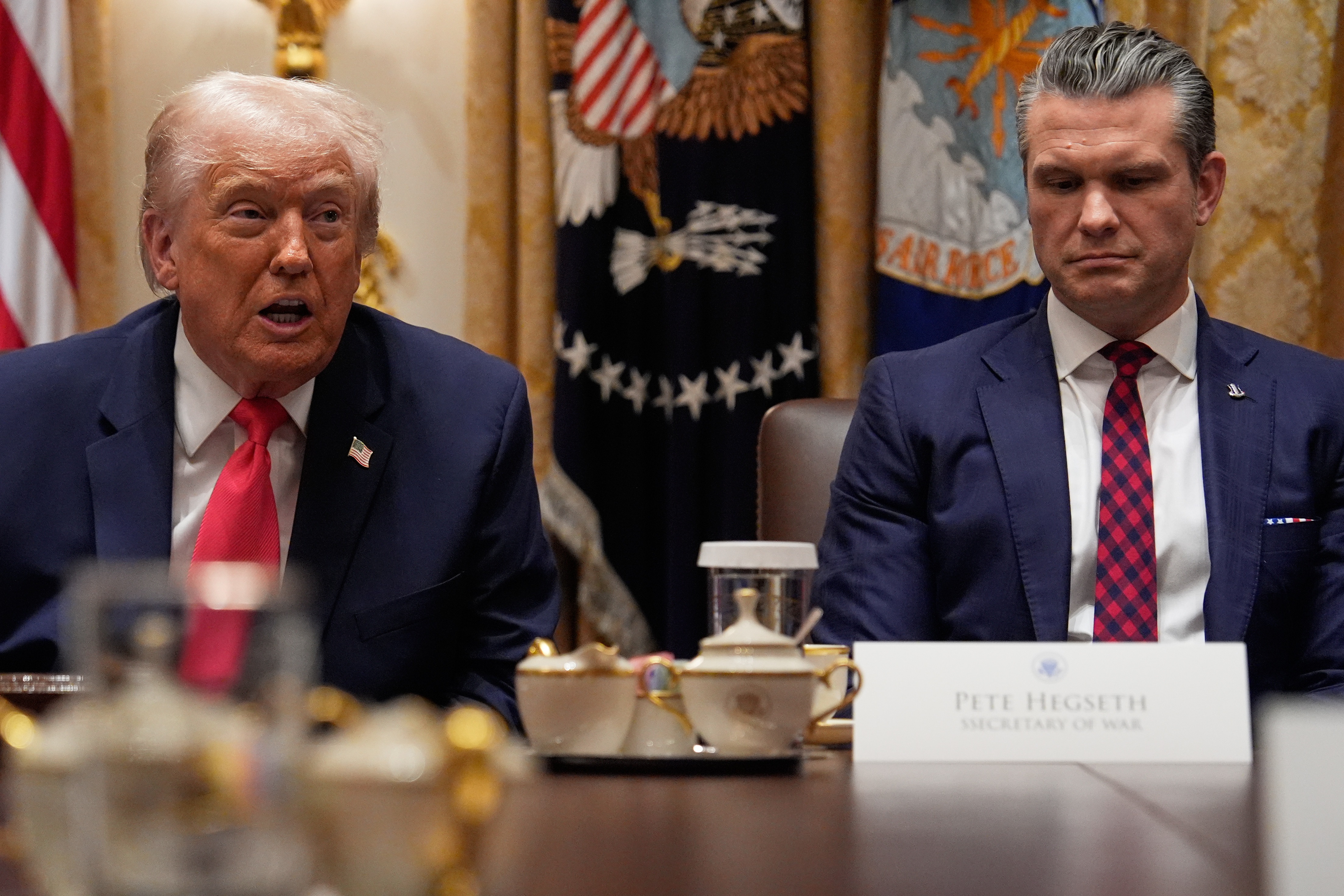 President Donald Trump speaks during a Cabinet meeting at the White House, Tuesday, Dec. 2, 2025, in Washington, as Secretary of Defense Pete Hegseth looks on.
